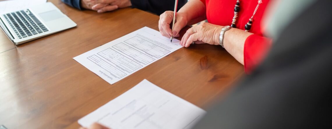 Dokumenty i laptop na biurku podczas sprawdzania formalności firmowych